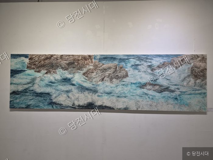 그미술관에서 파도와 바위가 그려진 대형 회화 작품이 전시되어 있다.