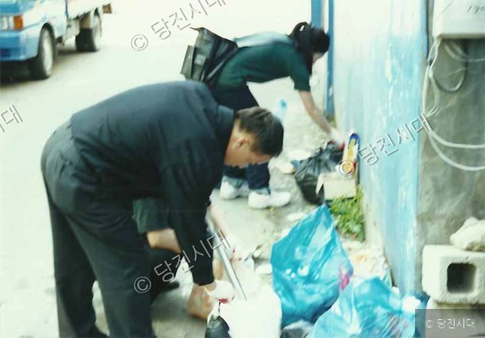 자원봉사자들이 거리에 버려진 쓰레기를 줍고 있다.