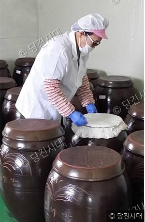 작업자가 전통 항아리를 점검하고 있다.