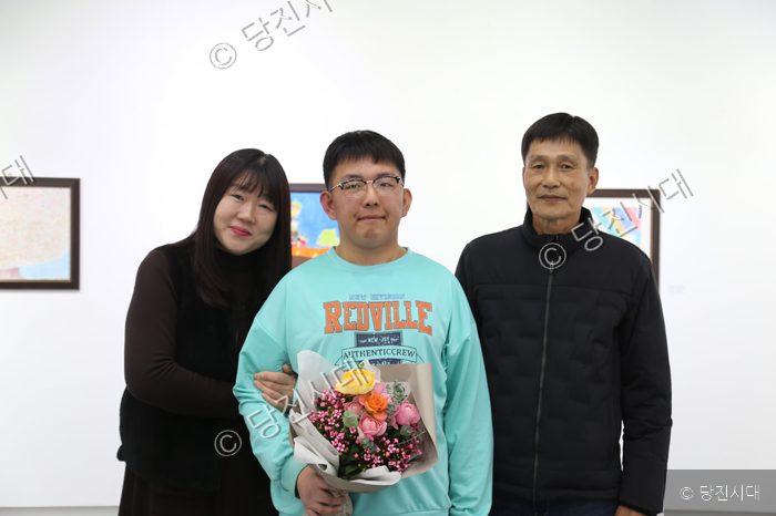 송규민 씨가 가족과 함께 꽃다발을 들고 기념 촬영을 하고 있다.