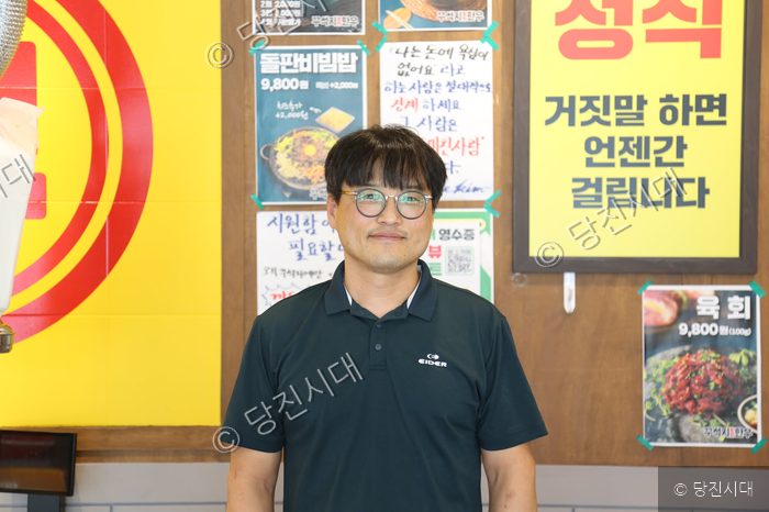식당 대표가 가게 내부에서 포즈를 취하고 있다.