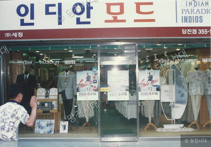 당진의 한 의류 매장 앞을 지나가는 시민의 모습.