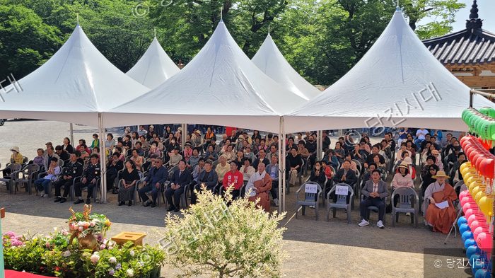 사찰 마당에 설치된 천막 아래서 시민들이 부처님 오신 날 봉축 법요식에 참석하고 있다.