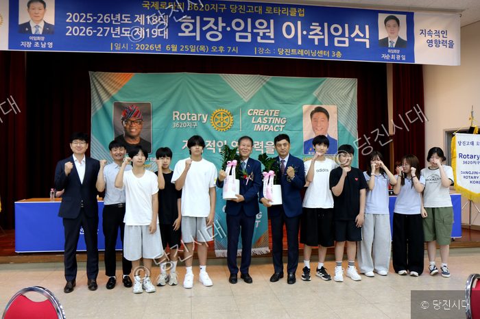 당진고대 로타리클럽 관계자들이 학생들에게 발전기금을 전달하며 기념사진을 촬영하고 있다.