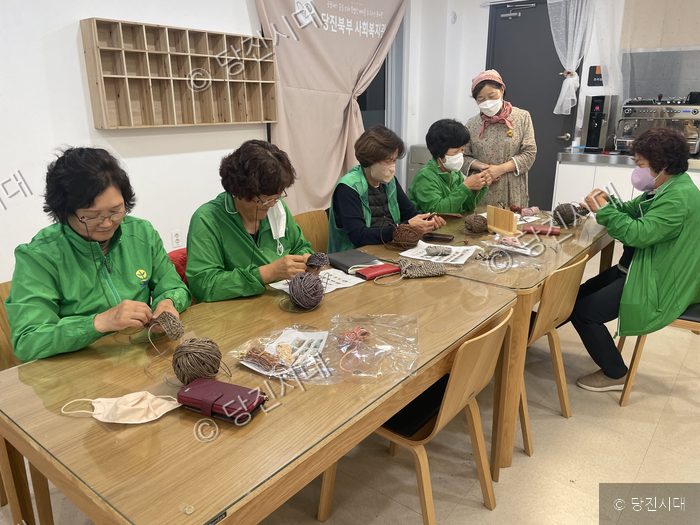 주민들이 테이블에 둘러앉아 공예 활동을 하고 있다.