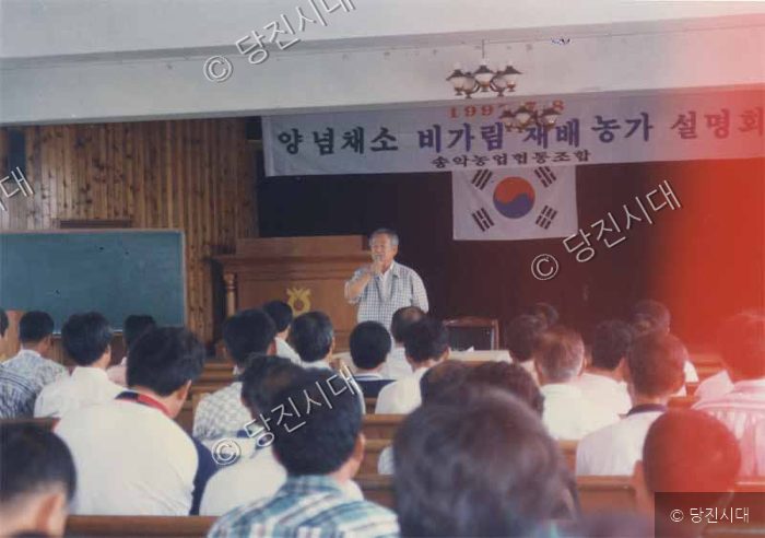 강연자가 농가 설명회에서 마이크를 잡고 발표하고 있다.