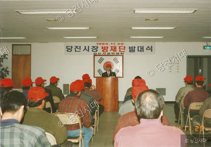 사람들이 실내에서 당진시장 방재단 발대식 행사에 참석하고 있다.