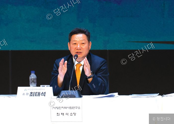 최태석 씨가 회의 테이블에서 발표하며 손짓을 하고 있다.