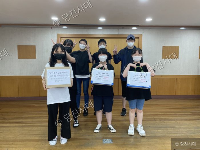 청소년들이 당진시동물보호소에 전달할 수제 간식을 들고 기념 촬영을 하고 있다.