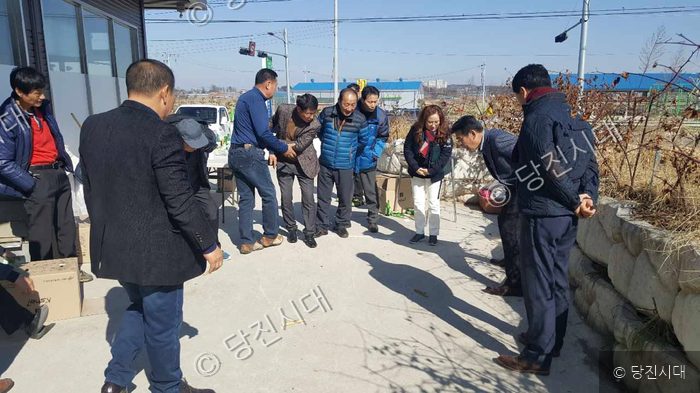 주민들이 야외에서 전통 놀이인 윷놀이를 즐기며 화합을 다지고 있다.