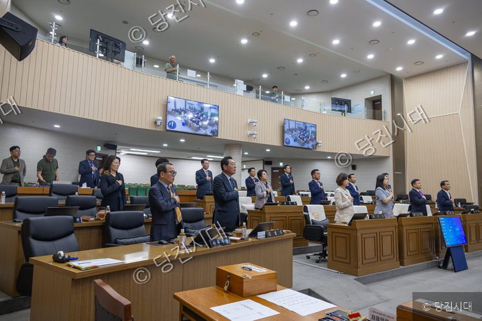 의원들이 의사당에서 국민의례를 하고 있다.