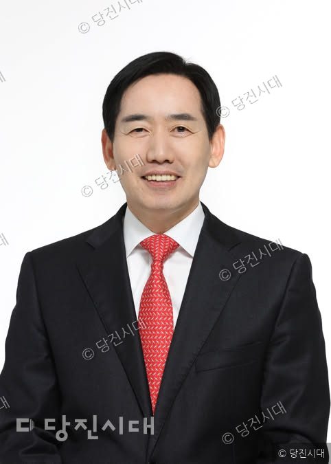 정용선 국민의힘 당진시 당협위원장이 정장 차림으로 미소 짓고 있다.