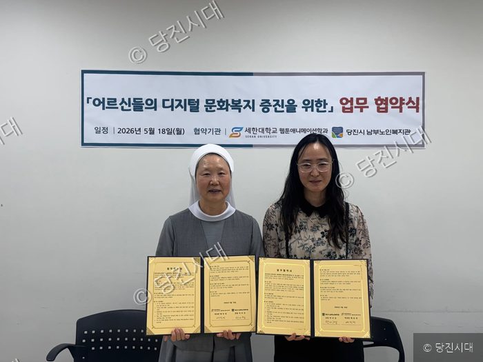 두 기관 박미경 관장이 업무 협약서를 들어 보이고 있다.