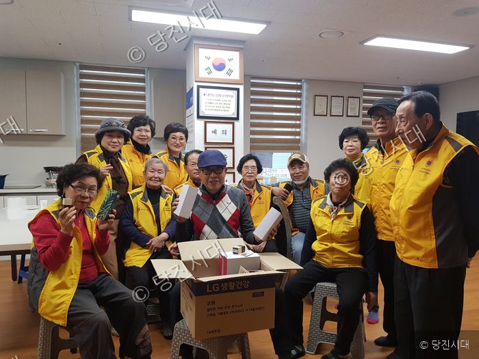 노인회원들이 후원물품을 전달받고 기념촬영을 하고 있다.