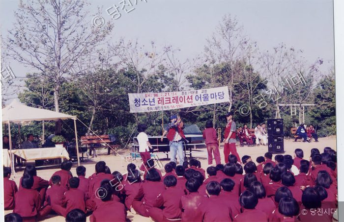 야외 운동장에서 청소년들이 레크리에이션 행사에 참여하고 있다.