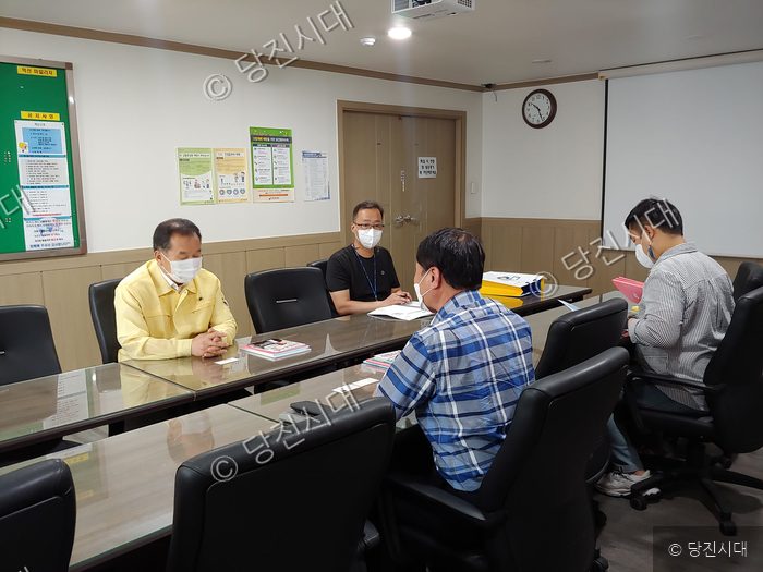 면장과 관계자들이 회의실에 모여 대화를 나누고 있다.
