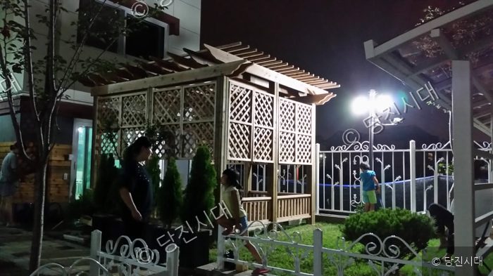 고혁준 대표 등이 목공방 외부에 설치된 파고라 정원에서 야간 휴식을 취하고 있다.