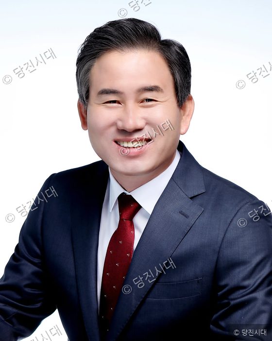 김봉균 의원이 정장 차림으로 밝게 미소 지으며 카메라를 응시하고 있다