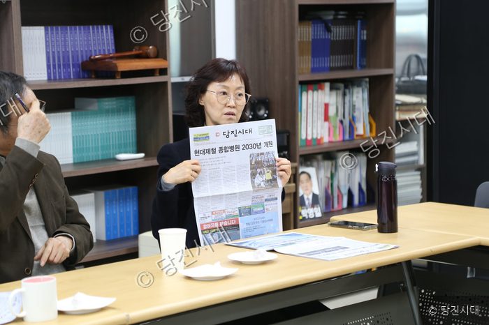 유양희 위원장이 지역신문을 펼쳐 보이며 의견을 말하고 있다.