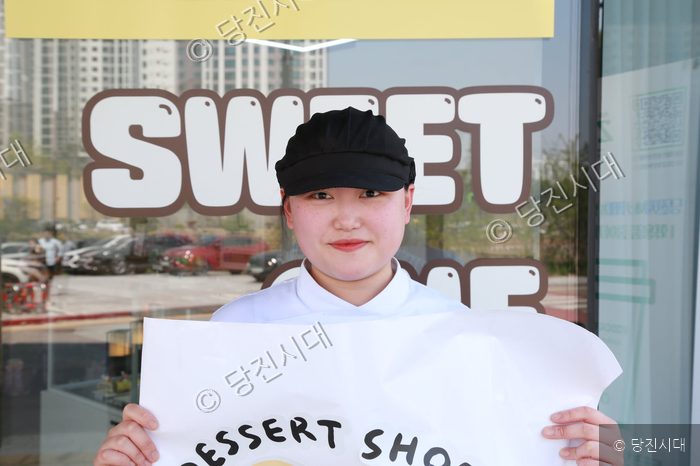 단한날 정채희 대표가 디저트 가게 앞에서 포즈를 취하고 있다.