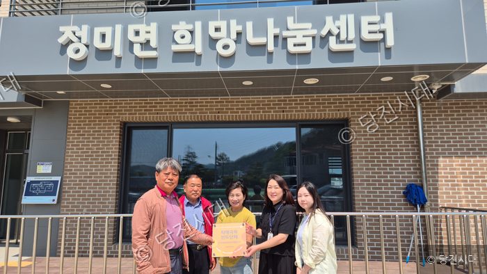 정미면 희망나눔센터 관계자들이 치매극복 선도단체 지정 현판을 들고 기념 촬영을 하고 있다.