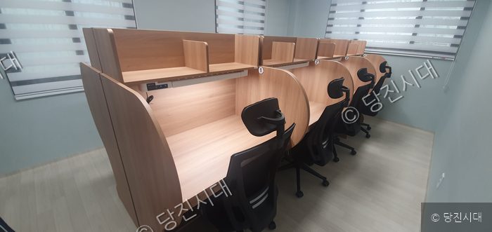 아파트 단지 내 스터디룸에 개인 독서실 책상들이 줄지어 놓여 있다.