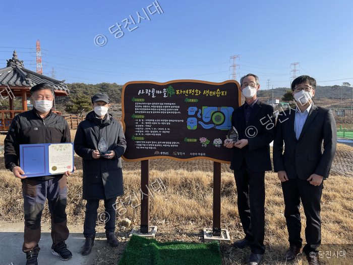 당진시 정미면 사관리에서 관계자들이 생태습지 안내판 옆에 기념 포즈를 취하고 있다.
