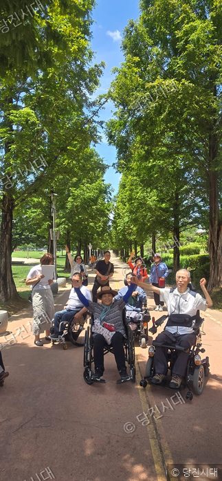 장애인달팽이문학회 회원들이 박두진문학관에서 산책하며 기념촬영을 하고 있다.