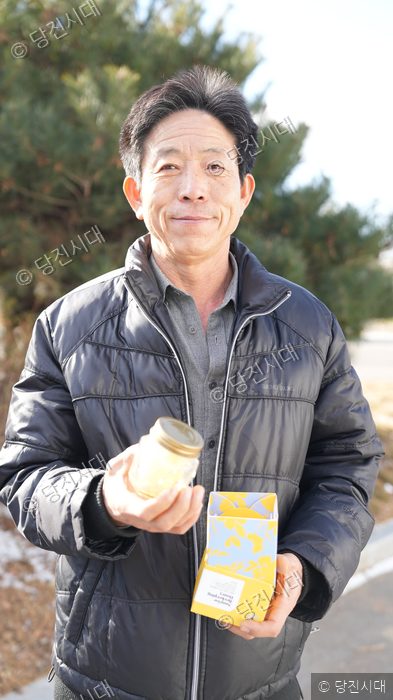 해돋이양봉 박정수 대표가 꿀 제품을 들어 보이며 미소 짓고 있다.