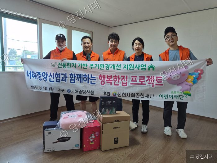 봉사자들이 주거환경개선 지원사업 물품과 함께 기념촬영을 하고 있다.