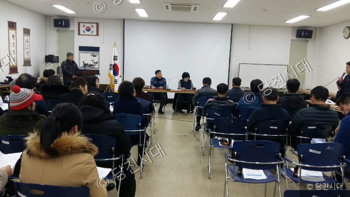 실내 회의실에서 주민들이 모여 회의를 진행하고 있다.