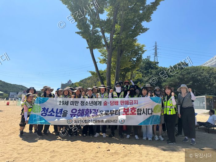 당진시 청소년유해환경감시단원들이 해수욕장에서 청소년 보호 캠페인을 벌이고 있다.