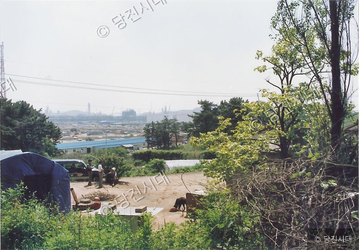 당진 지역의 한 주택가 풍경과 멀리 보이는 산업단지 모습.
