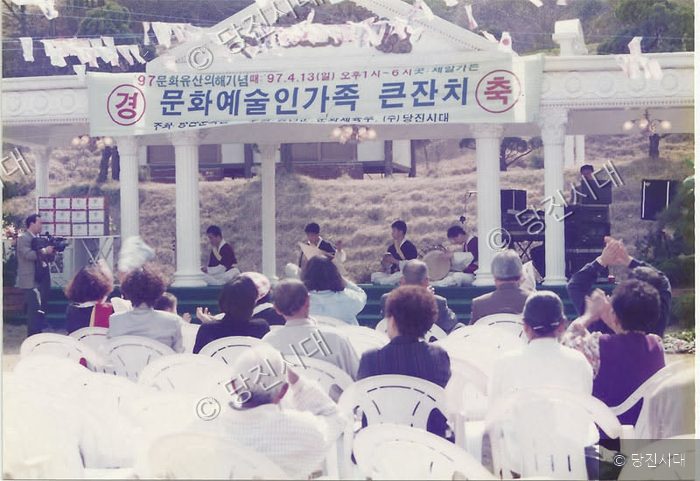 야외 무대에서 사람들이 문화예술인가족 큰잔치 행사를 관람하고 있다.