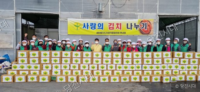 주민들이 김장 김치 나눔 봉사를 기념하며 포즈를 취하고 있다.