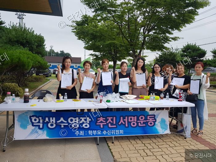 학부모들이 학생수영장 건립을 위한 서명운동을 벌이고 있다.