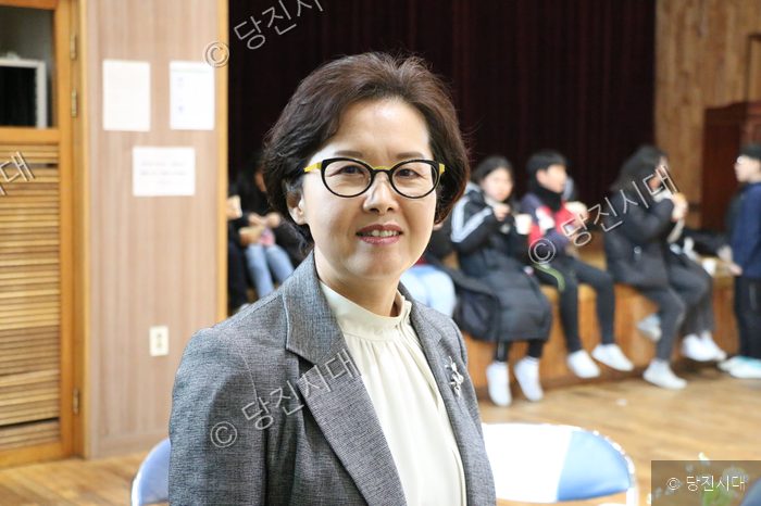 계성초 교장이 카메라를 향해 미소 짓고 있다.