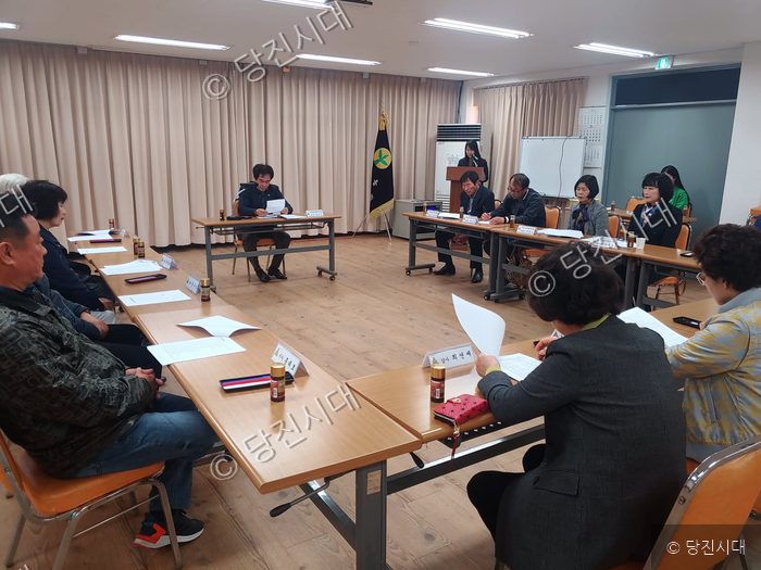 사람들이 회의실에 모여 회의를 진행하고 있다.