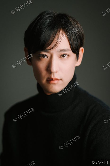 김재승 단장이 검은색 터틀넥을 입고 정면을 응시하고 있다.