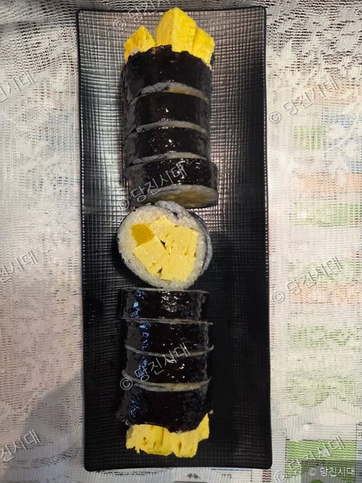 접시에 썰어놓은 김밥과 달걀말이가 놓여 있다.