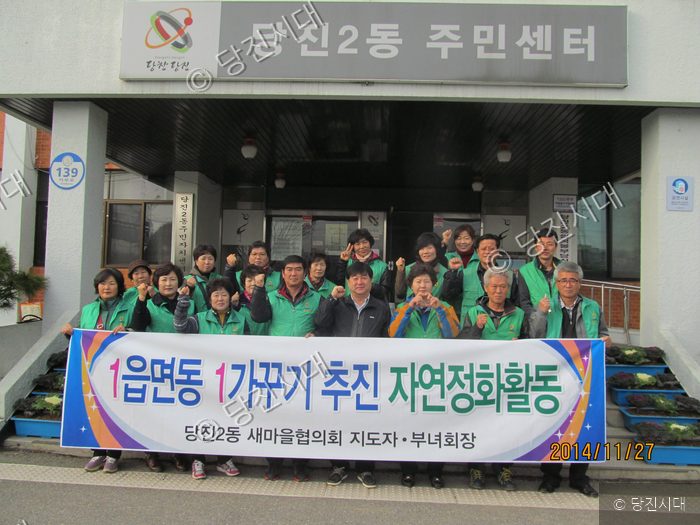 당진2동 주민센터 앞에서 새마을협의회원들이 자연정화활동 기념 사진을 찍고 있다.