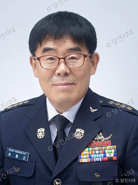 당진소방서 우강면의용소방대장 유종근이 정복을 입고 정면을 바라보며 미소 짓고 있다.