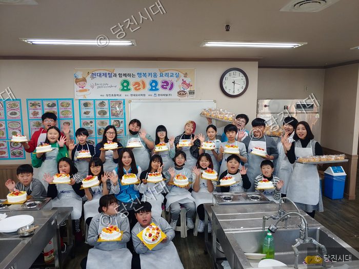 당진초등학교 학생들이 현대제철과 함께하는 행복키움 요리교실에서 만든 케이크를 들고 기념 촬영을 하고 있다.