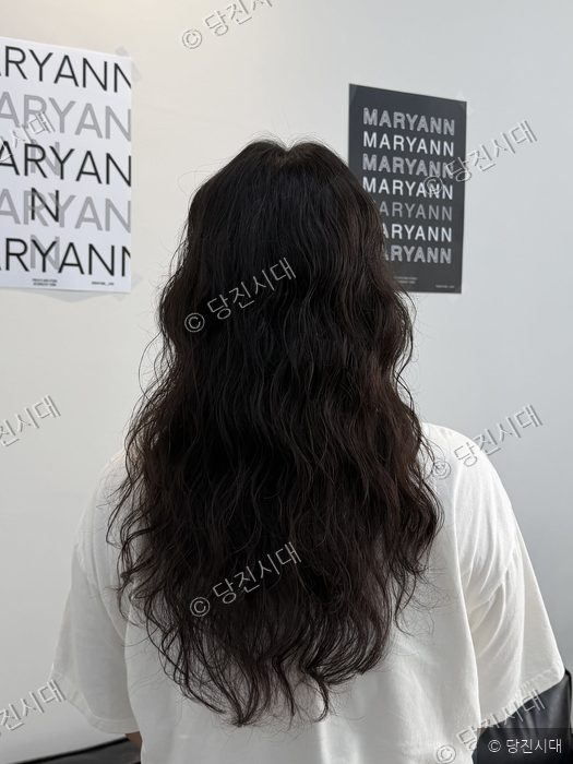 미용실에서 정유빈 원장이 웨이브 펌을 한 긴 머리를 보여주고 있다.