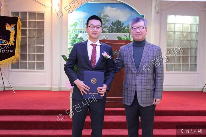 양재경 회장이 표창장이나 임명장을 들고 축하를 받고 있다.