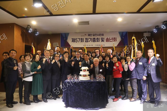 당진시민회 회원들이 송년회 및 정기총회를 열고 기념 케이크를 자르고 있다.