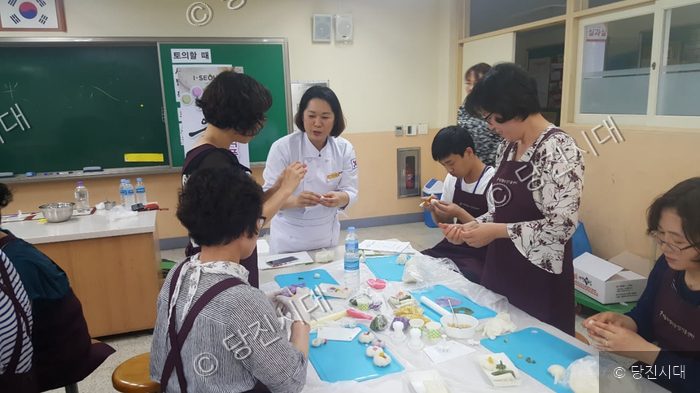 강사의 지도 아래 주민들이 전통 요리 만들기 강습에 참여하고 있다.