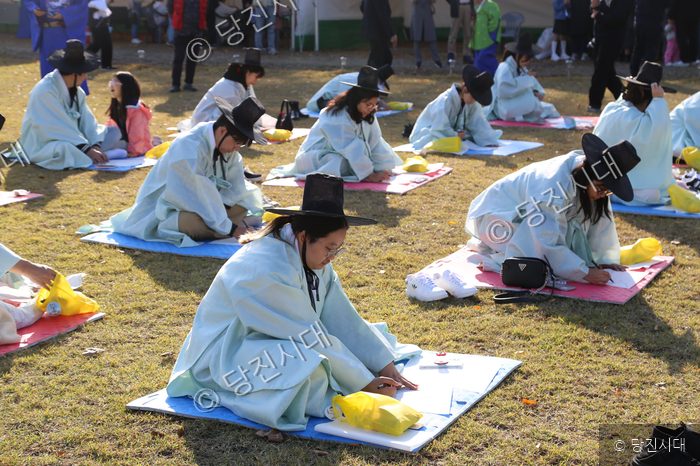 박지원 군수 등이 면천읍성 축제에서 전통 의상을 입고 글을 쓰고 있다.