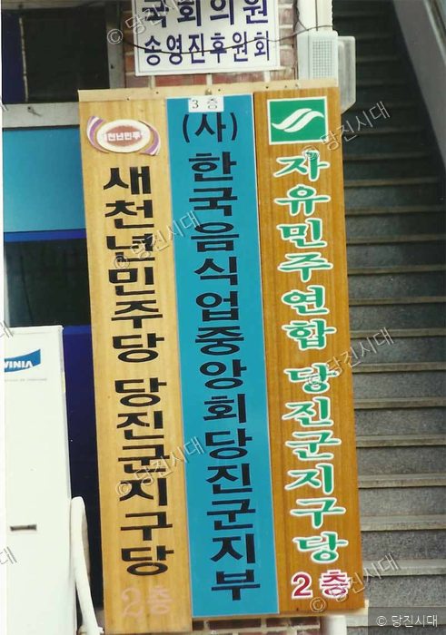 건물 입구에 여러 정당과 단체의 사무실 안내 표지판이 세워져 있다.