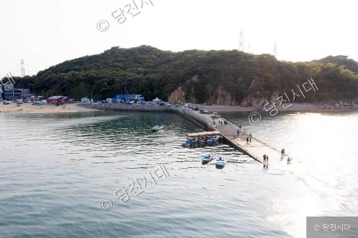 관광객들이 왜목마을 방파제를 걷고 있다.